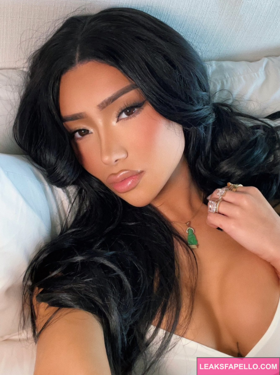 Nikita Dragun taking a selfie and wearing a white top showing the her cleavage