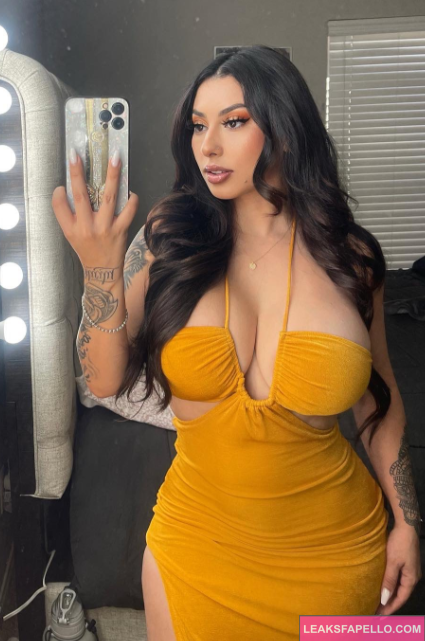 Maria Felicity takes a mirror selfie wearing skin tight yellow-brown gown