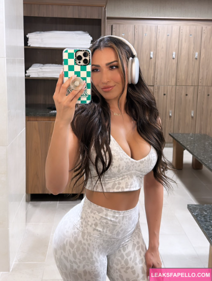 Alex Bravo wearing white headphones and dress and taking a sexy selfie 