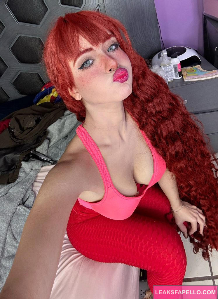 Bella Dueñas @belladuenas OnlyFans redhead big tits sexy tall only fans model wearing pink top and red leggings selfie sitting on the bed