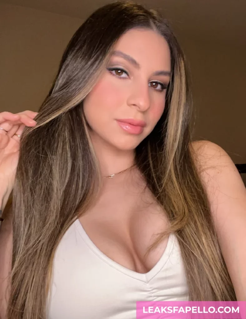Nina North, Curvy Big Tits Brunette OnlyFans model, is wearing a white tank top