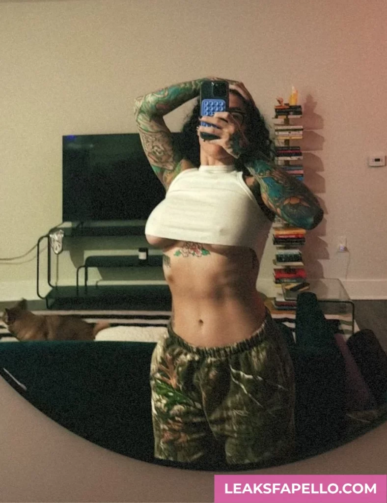 Bianca Bailee, thick curvy tattooed OnlyFans model, wearing white crop top and pants, showing the lower part of her tits