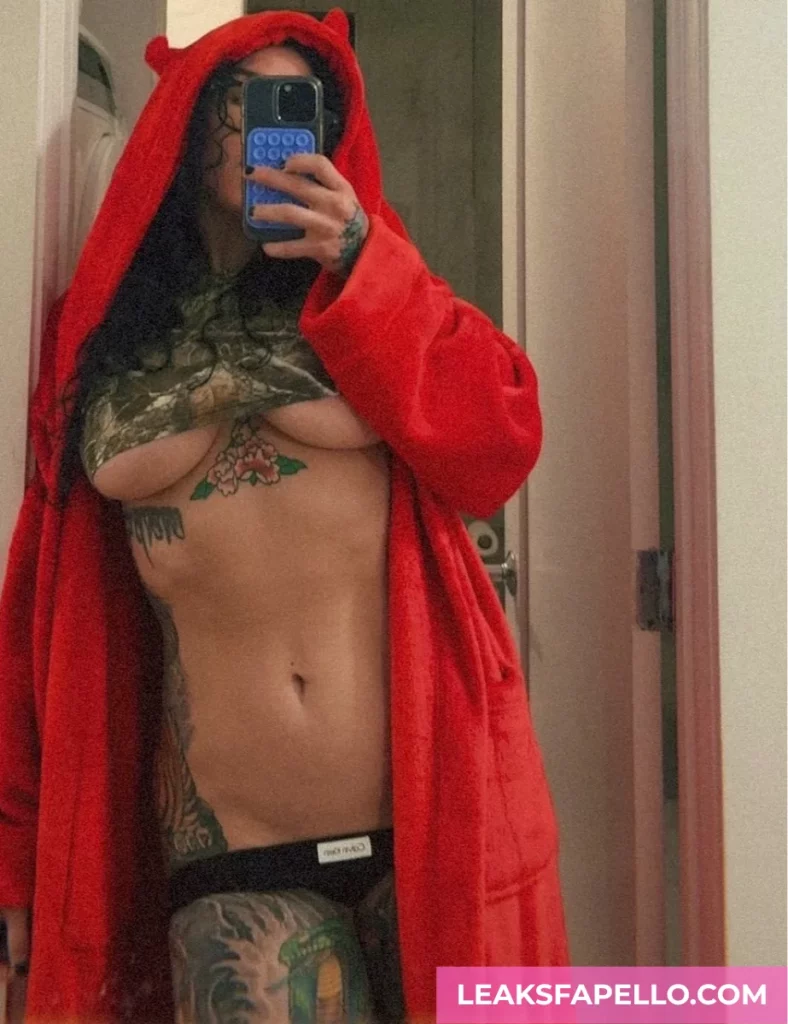 Bianca Bailee, thick curvy tattooed OnlyFans model, wearing a crop top and red fleece robe, exposing the lower portion of tits