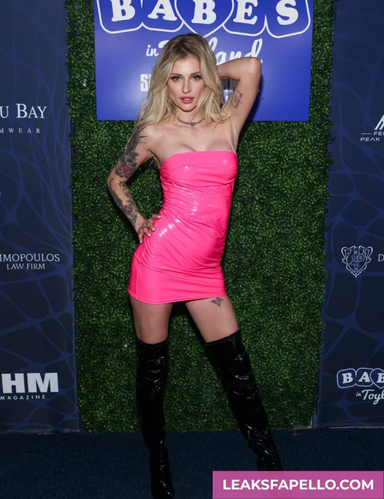 Hyley Winters, Blonde Babe with Big Tits and Tattoed OnlyFans model, wearing neon pink dress and black boots