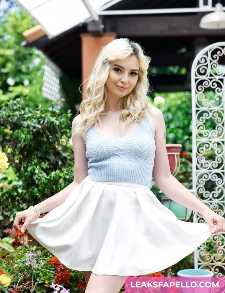 Lexi Lore, Blonde Bid Tits Pierced and Tattooed OnlyFans model, wearing a blue top and white skirt