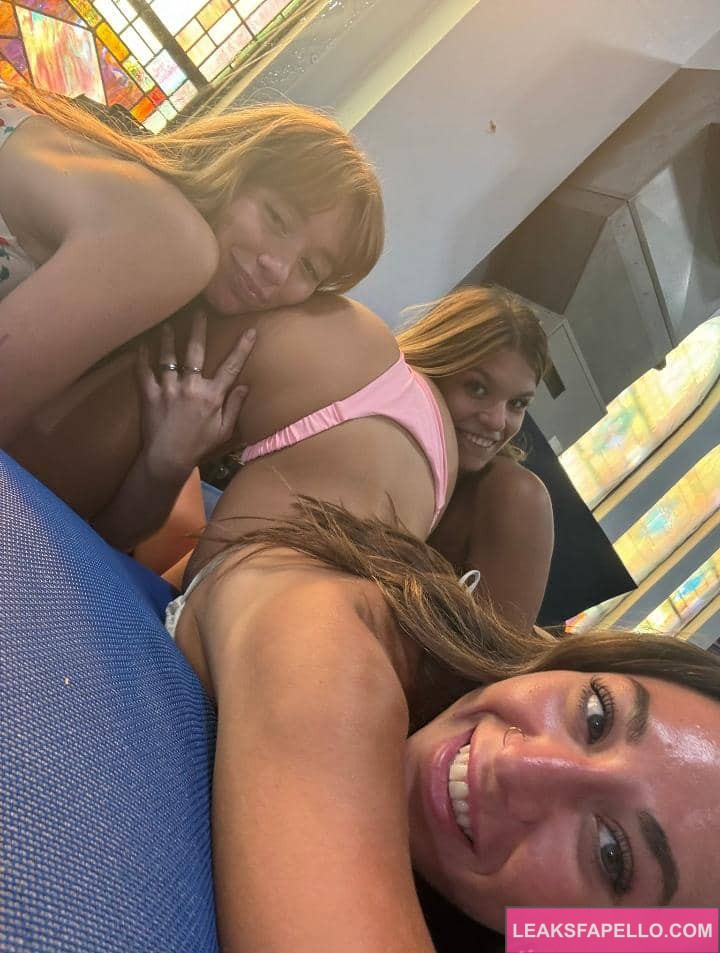 Avery Leigh with two girls holding her thighs