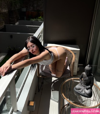 Lola Knox leaning on the balcony bar in a sexy way