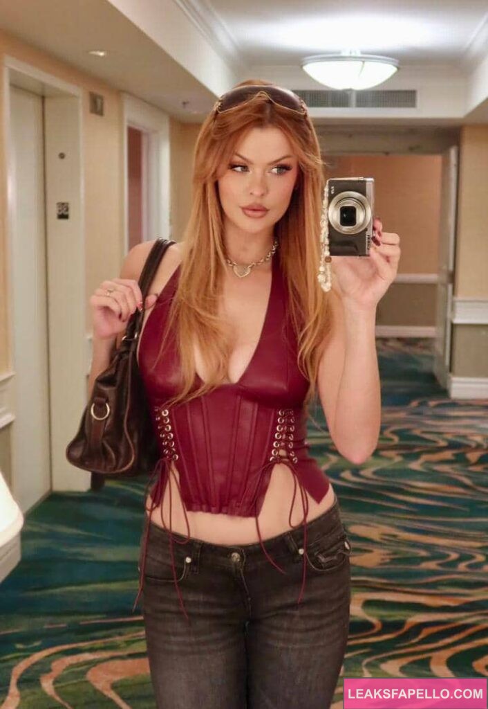 Elly Clutch taking a mirror selfie using her camera