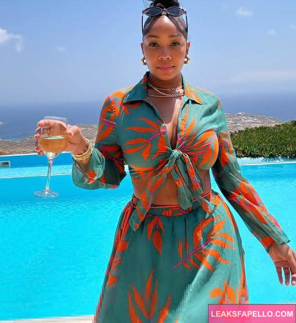 Candy Mary holding a glass of champagne beside a pool